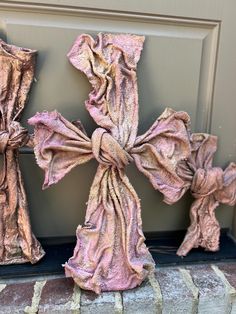 three pink crosses are sitting on the front door sill, one is made out of fabric