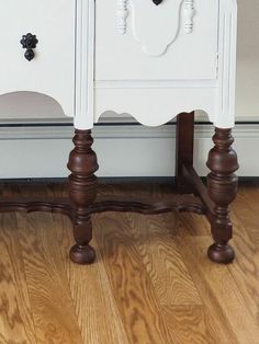 a white dresser sitting on top of a hard wood floor