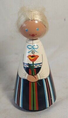 a small wooden doll with blonde hair and blue eyes