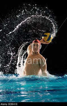 a man playing water polo in the pool with splashing water on his face and head