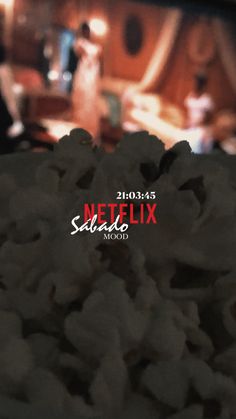 a close up of popcorn on a table with the netflix studio logo in the background