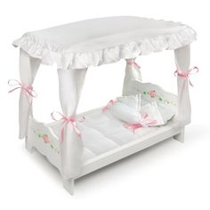 a white canopy bed with pink bows on the headboard and foot board, in front of a white background