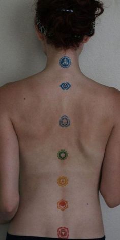 the back of a woman's body with seven chakras on it