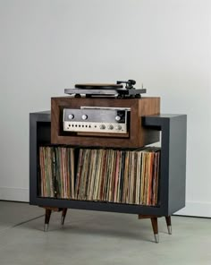 an old record player is sitting on top of a cabinet