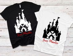 two t - shirts with mickey and minnie's castle on them, one is black and the other is white