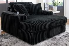 a large black chair sitting on top of a rug