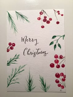 watercolor christmas card with berries and evergreens on white paper that says merry christmas