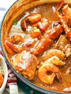 a pot filled with shrimp and rice on top of a table