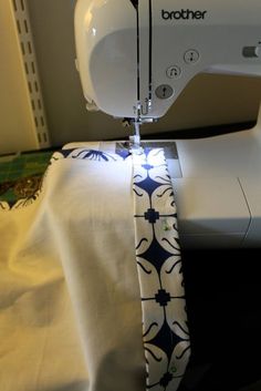 a sewing machine with a white and blue flowered design on it's side