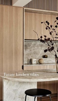 a kitchen with marble counter tops and stools in front of the counter top is a vase filled with flowers