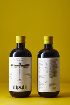 two bottles of liquid sitting next to each other on a yellow surface with the same color as the background