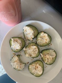 a white plate topped with cucumbers covered in cheese