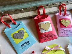 four valentine's day gift bags with hearts on them and tags attached to them