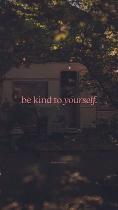 an rv parked in the woods with a quote on it that says, be kind to yourself