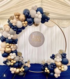 a balloon arch is decorated with blue, white and gold balloons