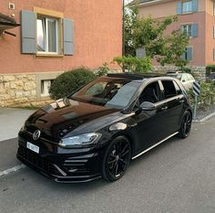 a black car is parked on the side of the road