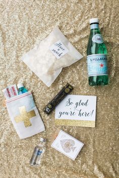 an assortment of personal items laid out on the floor next to a bottle of water