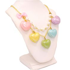 A cute and sweet statement necklace for Valentine's Day or lovecore season! This kawaii charm necklace includes Five heart shaped macaron ( macaroon ) pendants in pastel shades with a pearly finish and whipped cream center. Each necklace includes five 1" (2.5 cm) size charms hanging on a two-layered chain necklace with glass pearls on your choice of a 21" gold plated or silver plated chain. Accented with a baby pink fabric ribbon bow on one side. Necklace will be finished with a Fatally Feminine Sweet Pink Necklaces For Valentine's Day, Sweet Pink Necklace For Valentine's Day, Kawaii Necklaces For Valentine's Day, Cute White Necklace With Heart Charm, Kawaii Style Necklaces For Valentine's Day Gift, Cute Multicolor Charm Necklaces, Cute Heart Pendant Necklace With Heart Beads, Pastel Kawaii Jewelry Perfect For Gifts, Cute Multicolor Necklaces For Valentine's Day