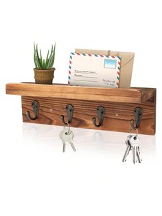 a wooden key rack with keys and mail on it, next to a potted plant