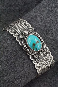 This stunning Kingman turquoise and sterling silver bracelet featuring a scalloped edge cuff was made by Navajo silversmith Michael Calladitto. The inside is signed M&R Calladitto and stamped Sterling.Size: 5 3/4" (will fit up to a 7 1/8" wrist)Gap: 1 3/8"Width: 1"Free shipping on all orders! We ship with USPS and always include tracking. All orders ship within a day of payment.Returns are accepted up to 30 days after you receive your order. Just send us a message. Our shop offers cash back or s Etched Turquoise Sterling Silver Jewelry, Southwestern Etched Turquoise Jewelry, Southwestern Style Etched Turquoise Jewelry, Southwestern Turquoise Etched Jewelry, Stamped Turquoise Bracelet, Turquoise Stamped Bracelet, Elegant Turquoise Concho Jewelry, Handmade Western Sterling Silver Bracelet For Gift, Kingman Turquoise