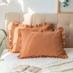 a bed with two pillows and a book on it