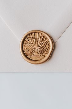 an envelope with a wax stamp on the front and side of it that has a sunburst design