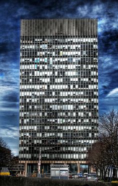 a very tall building with lots of windows on it's face and sky in the background