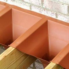 four clay planters are lined up against a brick wall