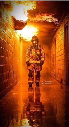 a firefighter is standing in the hallway with flames coming out of his back door