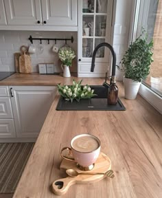 a cup of coffee sitting on top of a kitchen counter next to a wooden spoon