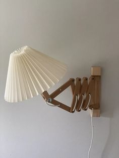 a lamp that is hanging on the wall next to a light fixture with wooden arms