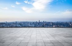 an empty concrete floor with the city in the background