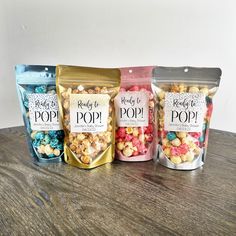 three bags of popcorn sitting on top of a wooden table