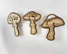 three wooden mushrooms are hanging on the wall