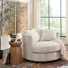 a living room filled with furniture and a fire place in front of a large window