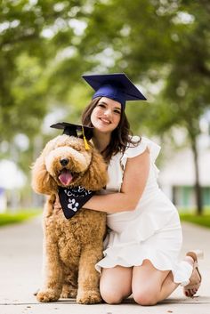 a woman in a graduation cap and gown kneeling down with her dog wearing a bandana