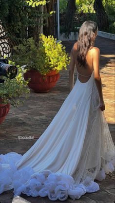 a woman in a white wedding dress standing next to flowers