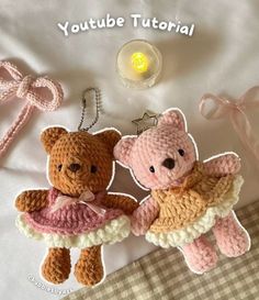 two crocheted teddy bears sitting on top of a bed next to each other