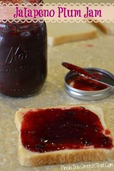 there is a jar of jam next to a piece of bread