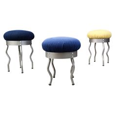 three stools with footstools in various colors and sizes, one on each side