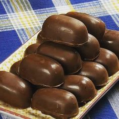 a plate filled with chocolate covered donuts on top of a blue and yellow table cloth