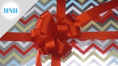 a red bow on top of a chevroned gift box with the words hnh above it