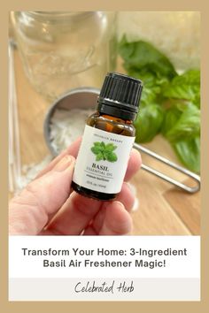 a hand holding an essential oil bottle with basil leaves in the background and text that reads transform your home 3 - ingredient basil air freshener magic