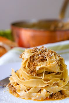 a white plate topped with pasta covered in sauce and toppings on top of it