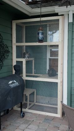 a large chicken cage sitting on top of a wooden shelf next to a patio table