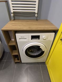 a washer and dryer in a small room with yellow doors on the wall