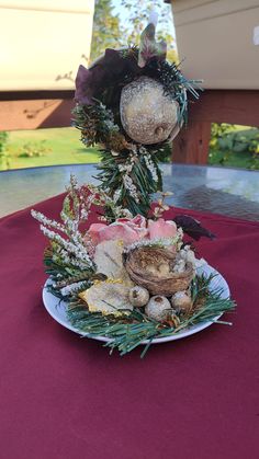 an arrangement of flowers and fruit on a plate