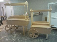 two wooden wagons sitting on top of a floor