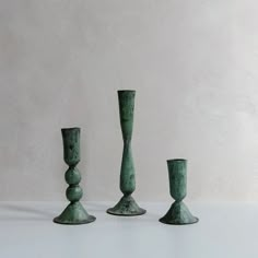 three green vases sitting next to each other