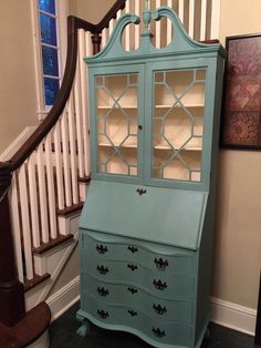 an old china cabinet is painted blue and has glass doors on the front, along with drawers